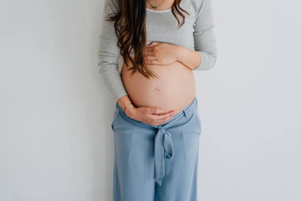 A pregnant woman gently cradling her belly, symbolizing the journey of fertility.