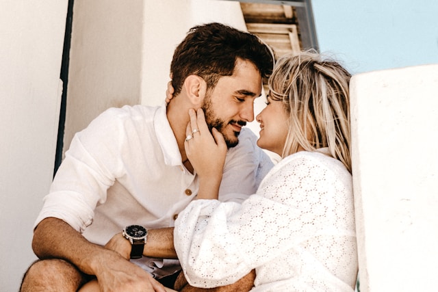 A loving couple sitting closely, gazing into each other's eyes.